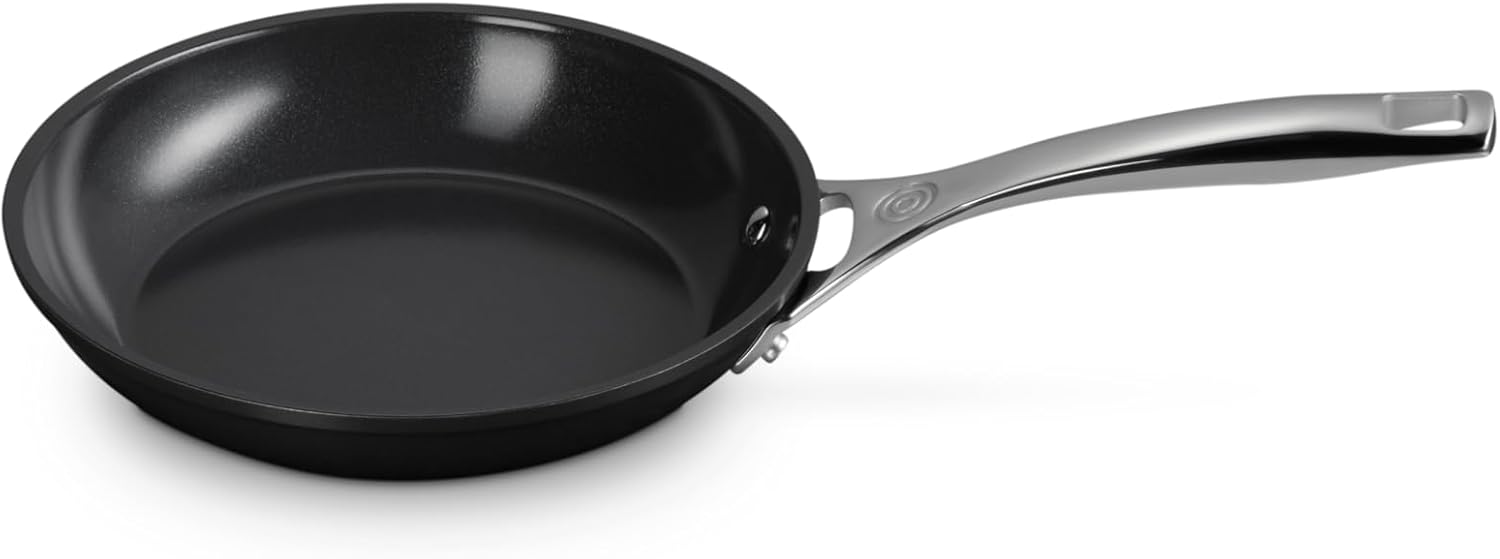 Le Creuset ceramic induction fry pan on a glass cooktop